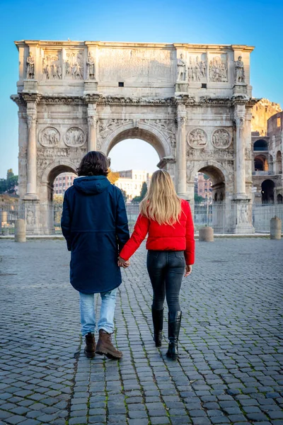 一对年轻夫妇要去罗马这对年轻夫妇手牵手 在泰特斯拱门前散步 — 图库照片