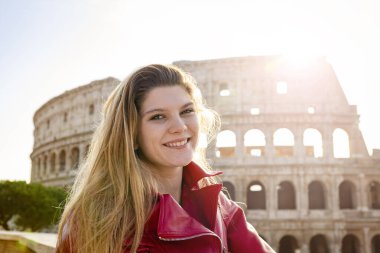 Roma 'ya seyahat eden genç bir kadın. Gülümseyen genç sarışın bir kadının arka plan resmi. Arkaplanda Colosseum ve sağda mesajınız için Kopyalama alanı.