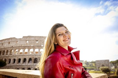 Roma 'ya seyahat eden genç bir kadın. Gülümseyen genç sarışın bir kadının arka plan resmi. Arkaplanda Colosseum ve sağda mesajınız için Kopyalama alanı.