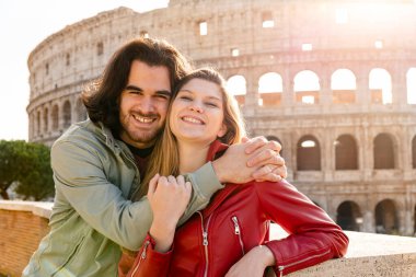 Roma 'ya seyahat eden genç bir çift. Çiftler Colosseum 'un önünde selfie çekmek için gülümsüyor ve sarılıyorlar..