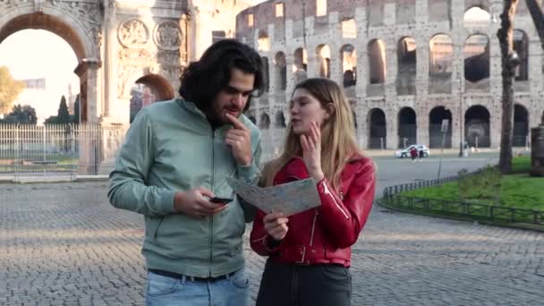 若いカップルはローマへ旅行する 若いカップルは街の地図上の方向を探しています — ストック動画