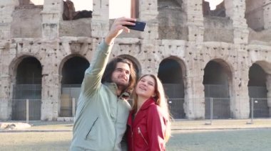 Roma 'ya seyahat eden genç bir çift. Güzel çift Colosseum 'un önünde komik selfie çekiyorlar..