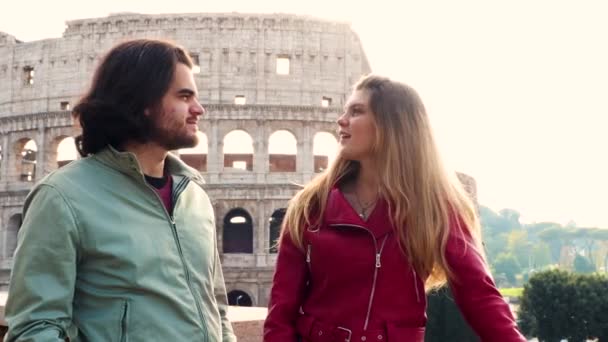 로마로 여행하는 아름다운 부부는 콜로세움 앞에서 이야기를 있습니다 여자가 친구를 — 비디오