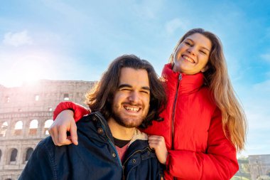 Roma 'ya seyahat eden genç bir çift. Çift gülümsüyor ve Colosseum 'un önünde selfie çekiyor..