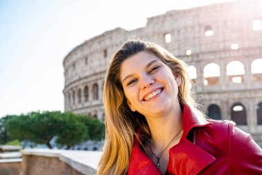 Roma 'ya seyahat eden genç bir kadın. Gülümseyen genç sarışın bir kadının arka plan resmi. Arkaplanda Colosseum ve sağda mesajınız için Kopyalama alanı.