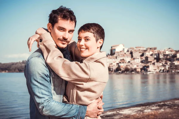 Genç çift Bracciano Gölü kıyısında kucaklaşıyor. İtalya 'nın Lazio kentindeki Anguillara Sabazia' ya seyahat eden güzel bir çift. Mesajınız için klasik atmosfer ve kopyalama alanı.