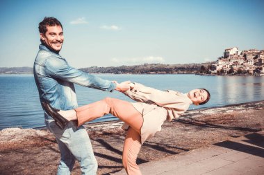 Genç çift İtalya 'da Bracciano Gölü kıyısında dans ediyor ve eğleniyor. Güzel bir İtalyan köyü olan Anguillara Sabazia 'ya seyahat eden çift..