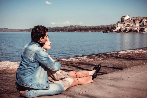 Beautiful Couple Sitting Shore Lake Bracciano Young Couple Embraces While — Stockfoto