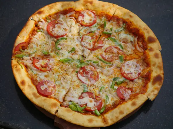 Hindistan 'da domates, kapsiyum ve soğanla kaplı vejetaryen peynirli pizza. Hint sebzeli pizza.