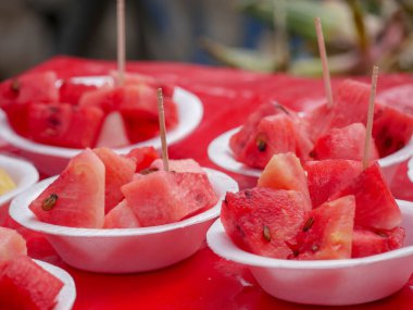 Dilimlenmiş kırmızı karpuz küplerini plastik bardakta kapat.