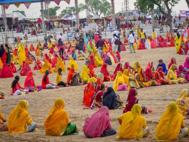 Puşkar, Rajasthan / Hindistan - 5 Kasım 2019: İtme karlı çölü stadyumunda dans gösterisi yapan köylü kadınlar Hindistan 'ın en büyük sığır ve kültür fuarı deve fuarında geleneksel elbiseleriyle dans ediyorlar.