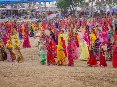 Puşkar, Rajasthan / Hindistan - 5 Kasım 2019: İtme karlı çölü stadyumunda dans gösterisi yapan köylü kadınlar Hindistan 'ın en büyük sığır ve kültür fuarı deve fuarında geleneksel elbiseleriyle dans ediyorlar.