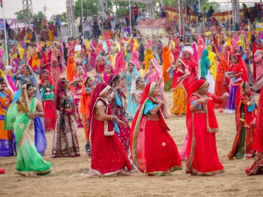 Puşkar, Rajasthan / Hindistan - 5 Kasım 2019: İtme karlı çölü stadyumunda dans gösterisi yapan köylü kadınlar Hindistan 'ın en büyük sığır ve kültür fuarı deve fuarında geleneksel elbiseleriyle dans ediyorlar.