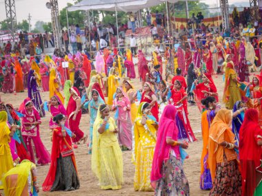 Puşkar, Rajasthan / Hindistan - 5 Kasım 2019: İtme karlı çölü stadyumunda dans gösterisi yapan köylü kadınlar Hindistan 'ın en büyük sığır ve kültür fuarı deve fuarında geleneksel elbiseleriyle dans ediyorlar.