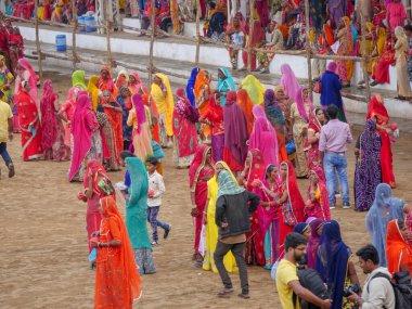 Puşkar, Rajasthan / Hindistan - 5 Kasım 2019: İtme karlı çölü stadyumunda dans gösterisi yapan köylü kadınlar Hindistan 'ın en büyük sığır ve kültür fuarı deve fuarında geleneksel elbiseleriyle dans ediyorlar.