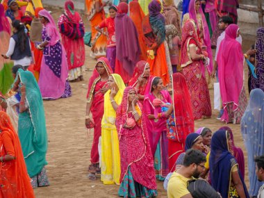 Puşkar, Rajasthan / Hindistan - 5 Kasım 2019: İtme karlı çölü stadyumunda dans gösterisi yapan köylü kadınlar Hindistan 'ın en büyük sığır ve kültür fuarı deve fuarında geleneksel elbiseleriyle dans ediyorlar.