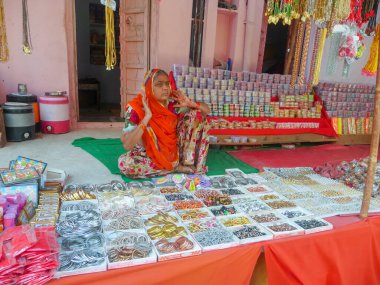 Pushkar, Rajasthan / Hindistan - 5 Kasım 2019: Kırsal Hint köylü kadın bilezik satıyor. Hindistan 'da kadınların, kadınların ve kızların kullandığı renkli bileziklerin gösterimi.