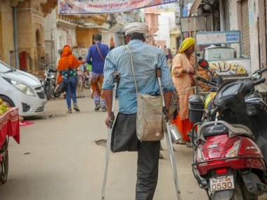 Pushkar, Rajasthan / Hindistan - 5 Kasım 2019: Fakir bir Özürlü Adam Sokakta Baisakhi koltuk değneklerinin yardımıyla yürüyor