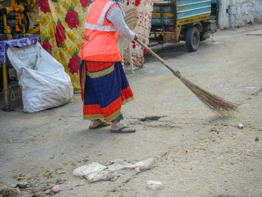 Pushkar, Rajasthan / Hindistan - 5 Kasım 2019: Hintli kadın süpürge bakım kenti sokak yolu.