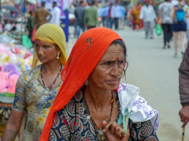 Pushkar, Rajasthan / Hindistan - 5 Kasım 2019: Hindistan kırsalındaki sokak pazarı. Hindistan 'ın Pushkar şehrindeki kırsal Hint kasabasında yürüyen kadın ve erkeklerle dolu kalabalık bir cadde.