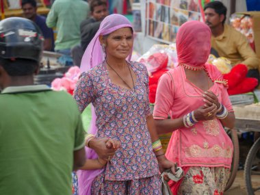 Pushkar, Rajasthan / Hindistan - 5 Kasım 2019: Hindistan kırsalındaki sokak pazarı. Hindistan 'ın Pushkar şehrindeki kırsal Hint kasabasında yürüyen kadın ve erkeklerle dolu kalabalık bir cadde.