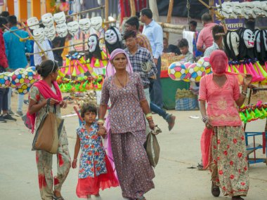 Pushkar, Rajasthan / Hindistan - 5 Kasım 2019: Hindistan kırsalındaki sokak pazarı. Hindistan 'ın Pushkar şehrindeki kırsal Hint kasabasında yürüyen kadın ve erkeklerle dolu kalabalık bir cadde.