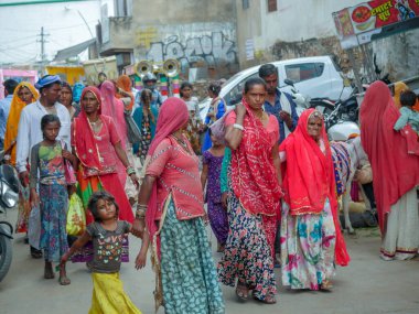 Pushkar, Rajasthan / Hindistan - 5 Kasım 2019: Hindistan kırsalındaki sokak pazarı. Hindistan 'ın Pushkar şehrindeki kırsal Hint kasabasında yürüyen kadın ve erkeklerle dolu kalabalık bir cadde.