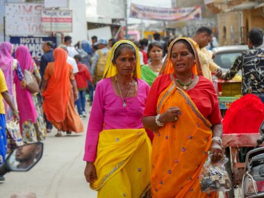 Pushkar, Rajasthan / Hindistan - 5 Kasım 2019: Hindistan kırsalındaki sokak pazarı. Hindistan 'ın Pushkar şehrindeki kırsal Hint kasabasında yürüyen kadın ve erkeklerle dolu kalabalık bir cadde.