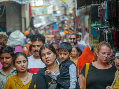 Pushkar, Rajasthan / Hindistan - 5 Kasım 2019: Hindistan kırsalındaki sokak pazarı. Hindistan 'ın Pushkar şehrindeki kırsal Hint kasabasında yürüyen kadın ve erkeklerle dolu kalabalık bir cadde.