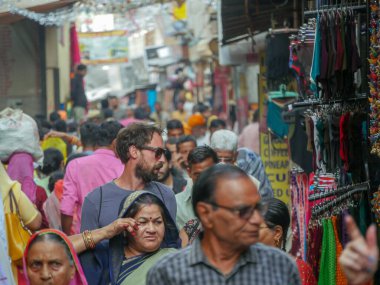 Pushkar, Rajasthan / Hindistan - 5 Kasım 2019: Hindistan kırsalındaki sokak pazarı. Hindistan 'ın Pushkar şehrindeki kırsal Hint kasabasında yürüyen kadın ve erkeklerle dolu kalabalık bir cadde.