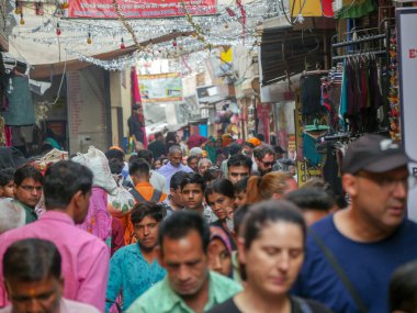 Pushkar, Rajasthan / Hindistan - 5 Kasım 2019: Hindistan kırsalındaki sokak pazarı. Hindistan 'ın Pushkar şehrindeki kırsal Hint kasabasında yürüyen kadın ve erkeklerle dolu kalabalık bir cadde.