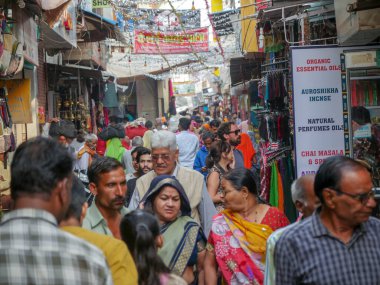 Pushkar, Rajasthan / Hindistan - 5 Kasım 2019: Hindistan kırsalındaki sokak pazarı. Hindistan 'ın Pushkar şehrindeki kırsal Hint kasabasında yürüyen kadın ve erkeklerle dolu kalabalık bir cadde.
