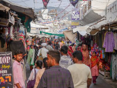 Pushkar, Rajasthan / Hindistan - 5 Kasım 2019: Hindistan kırsalındaki sokak pazarı. Hindistan 'ın Pushkar şehrindeki kırsal Hint kasabasında yürüyen kadın ve erkeklerle dolu kalabalık bir cadde.