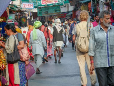 Pushkar, Rajasthan / Hindistan - 5 Kasım 2019: Hindistan kırsalındaki sokak pazarı. Hindistan 'ın Pushkar şehrindeki kırsal Hint kasabasında yürüyen kadın ve erkeklerle dolu kalabalık bir cadde.