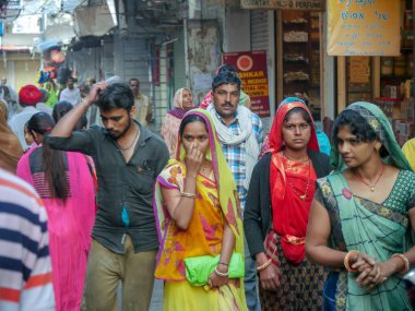 Pushkar, Rajasthan / Hindistan - 5 Kasım 2019: Hindistan kırsalındaki sokak pazarı. Hindistan 'ın Pushkar şehrindeki kırsal Hint kasabasında yürüyen kadın ve erkeklerle dolu kalabalık bir cadde.