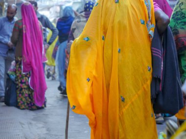 Pushkar, Rajasthan / Hindistan - 5 Kasım 2019: Hindistan kırsalındaki sokak pazarı. Hindistan 'ın Pushkar şehrindeki kırsal Hint kasabasında yürüyen kadın ve erkeklerle dolu kalabalık bir cadde.