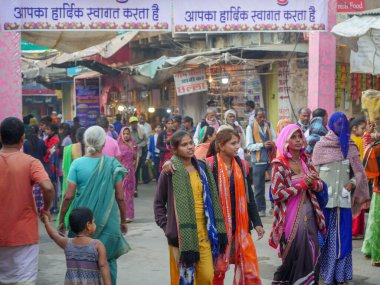 Pushkar, Rajasthan / Hindistan - 5 Kasım 2019: Hindistan kırsalındaki sokak pazarı. Hindistan 'ın Pushkar şehrindeki kırsal Hint kasabasında yürüyen kadın ve erkeklerle dolu kalabalık bir cadde.