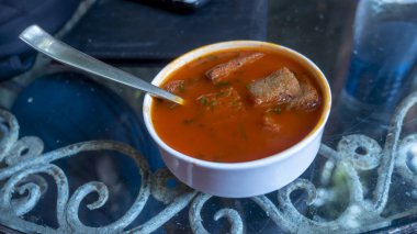 Tomato soup with toast pieces.