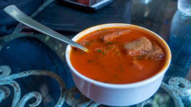 Tomato soup with toast pieces.