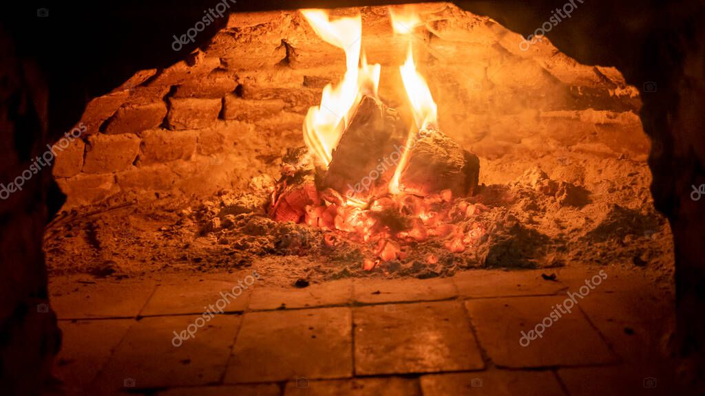 Wood fired oven. Flares of fire rising in the oven. Traditional style wood fired oven.
