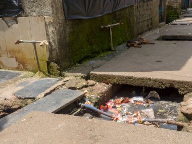 Mumbai, Maharashtra / India  March 2, 2020 : Open gutter sewer line in slum area of Mumbai, India.