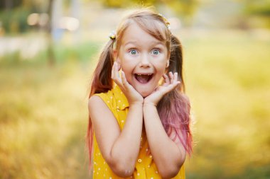 Dişsiz çocuklar gülümser. Küçük tatlı kız gülüyor, ilk süt dişini gösteriyor. Çocuk dişçiliği. Neşeli çocuk solu işaret ediyor