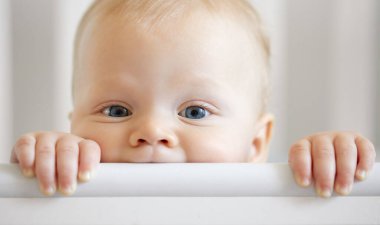 Komik bebek surat. İlk sütü olan ya da geçici dişleri olan küçük tatlı bebek bebek tahta beşik kemirir. Bebek, bebek odasında beşiğinde gülümsüyor.