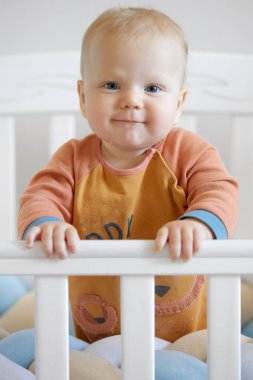 Komik bebek surat. İlk sütü ya da geçici dişleri olan yeni doğmuş tatlı bir erkek bebek. Bebek, bebek odasında beşiğinde gülümsüyor.