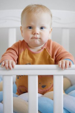 Komik bebek surat. İlk sütü ya da geçici dişleri olan yeni doğmuş tatlı bir erkek bebek. Bebek, bebek odasında beşiğinde gülümsüyor.