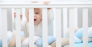 Küçük bebek beşiğinde ağlıyor, uyumak istiyor ve süt dişleri tırmanıyor. Pediatrik sorunlar