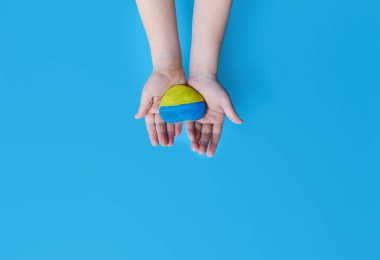 Çocukların elleri Ukrayna bayrağının renklerine boyanmış bir taşı tutuyor. Ukrayna 'da ABD, NATO ve Rusya arasındaki çatışma. Ukrayna 'daki Savaşı Durdurun 2022. 