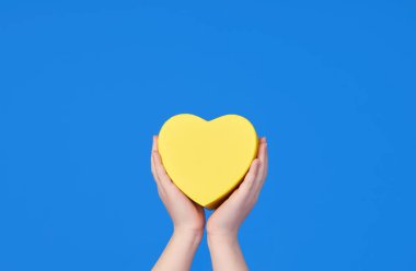 Çocukların elleri mavi arka planda sarı bir kalp tutar. Ukrayna bayrağının renkleri. Mesaj için yer. Pankart