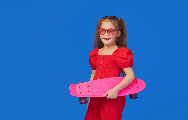 Cool Pequeña Niña Ropa Brillante Sienta Monopatín Mirando Cámara Aislada — Foto de Stock