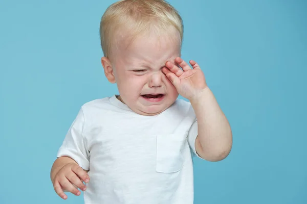 Little baby boy crying on blue background